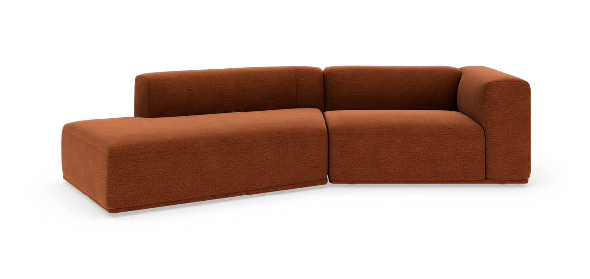 Modulsofa i terrakottafarvet stof med afrundede former i L‑form.