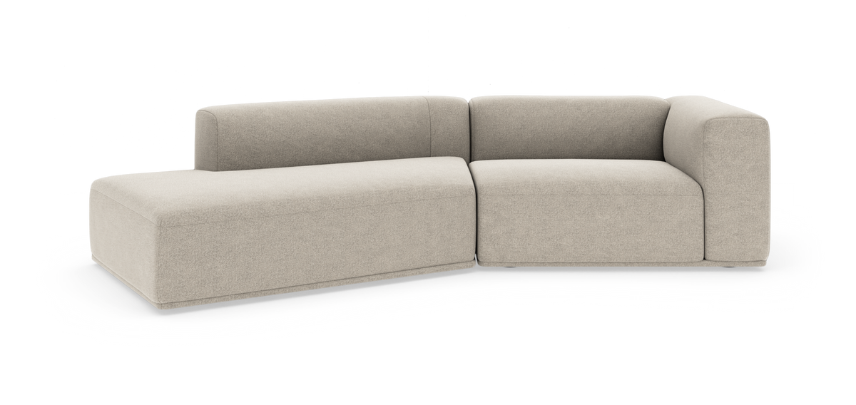 Beige modulsofa i L‑form med afrundede kanter på hvid baggrund.