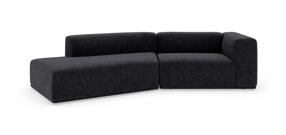 Mørkegrå L‑formet modulsofa med afrundede kanter, fritstående på hvid baggrund.