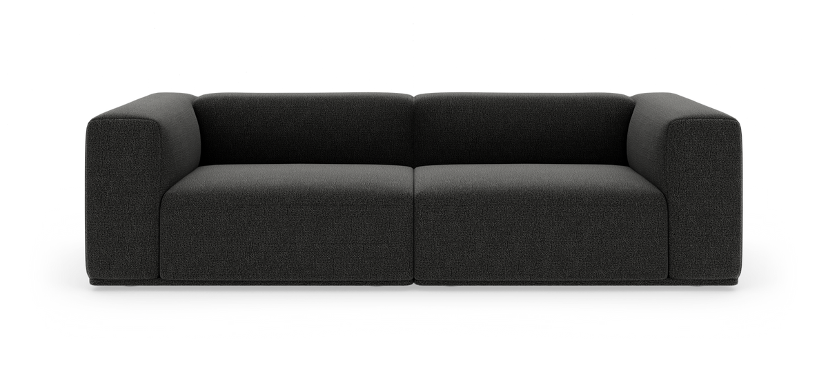Mørkegrå, moderne sofa med afrundede, voluminøse armlæn frilagt på hvid baggrund.