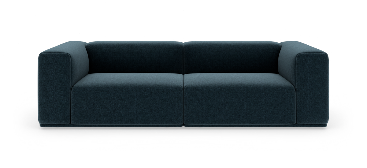 Mørkeblå moderne 2-personers sofa med brede blok-armlæn, set forfra, fritstående mod hvid baggrund.