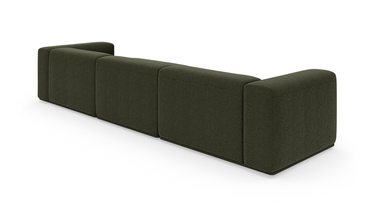 Mørkegrøn modulsofa set skråt bagfra på hvid baggrund.