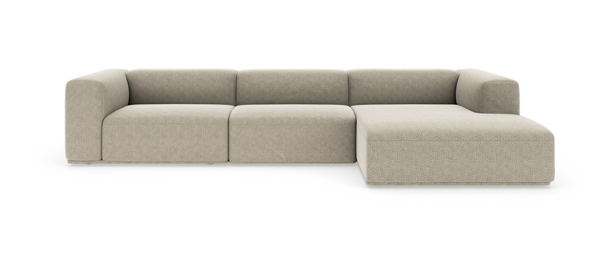 Beige modulsofa med chaiselong til højre i moderne, afrundet design på hvid baggrund.