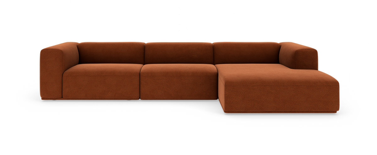 Modulsofa i rustfarvet stof med chaiselong til højre, fritlagt på hvid baggrund.