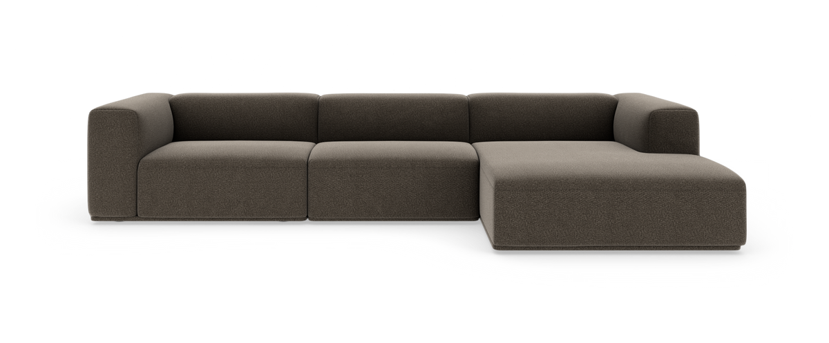 Modulsofa i brungråt stof med chaiselong til højre, fotograferet forfra på hvid baggrund.