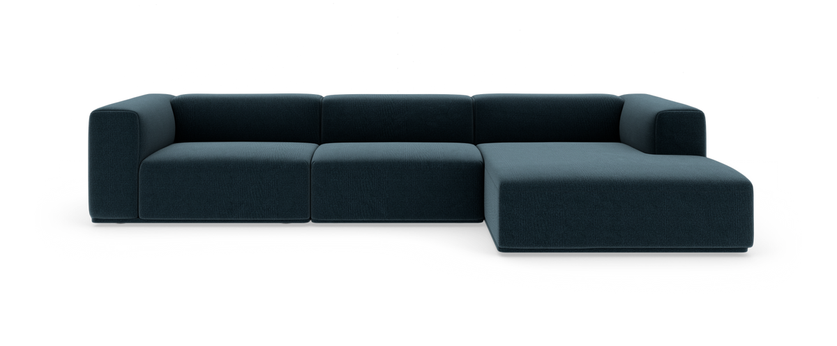 Modulær mørkeblå hjørnesofa med chaiselong til højre på hvid studiobaggrund.