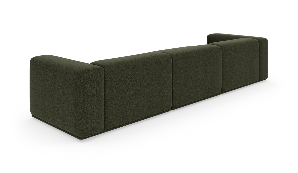 Modulsofa i mørkegrønt stof set skråt bagfra, frilagt på hvid baggrund.
