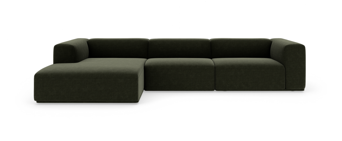 Mørkegrøn modulsofa i L-form med chaiselong til venstre, fotograferet mod hvid studiebaggrund.