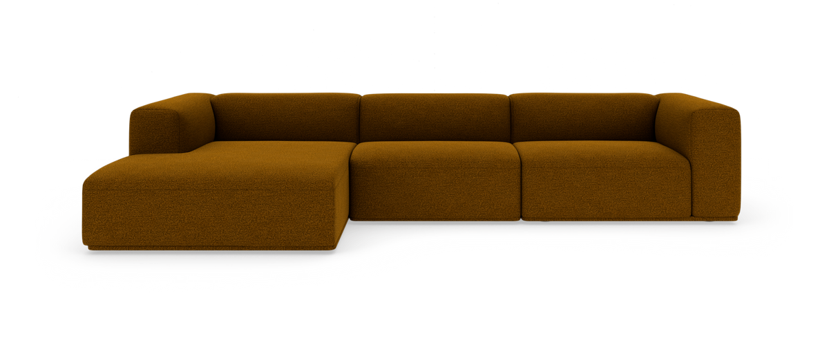 Modulær hjørnesofa i sennepsbrun bouclé med afrundede former, fritlagt på hvid baggrund.