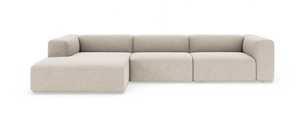 Beige modulsofa med venstrevendt chaiselong, lav profil og afrundede armlæn, frilagt på hvid baggrund.