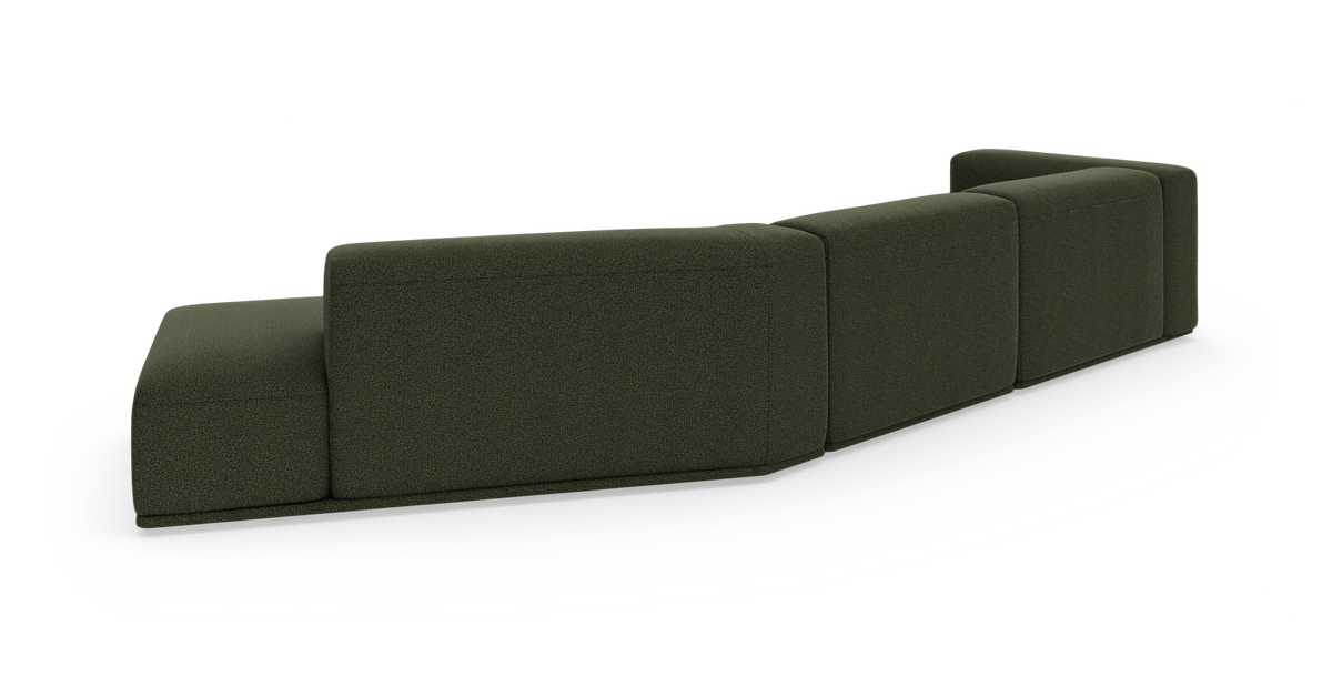 Mørkegrøn modulsofa set skråt bagfra på hvid baggrund.