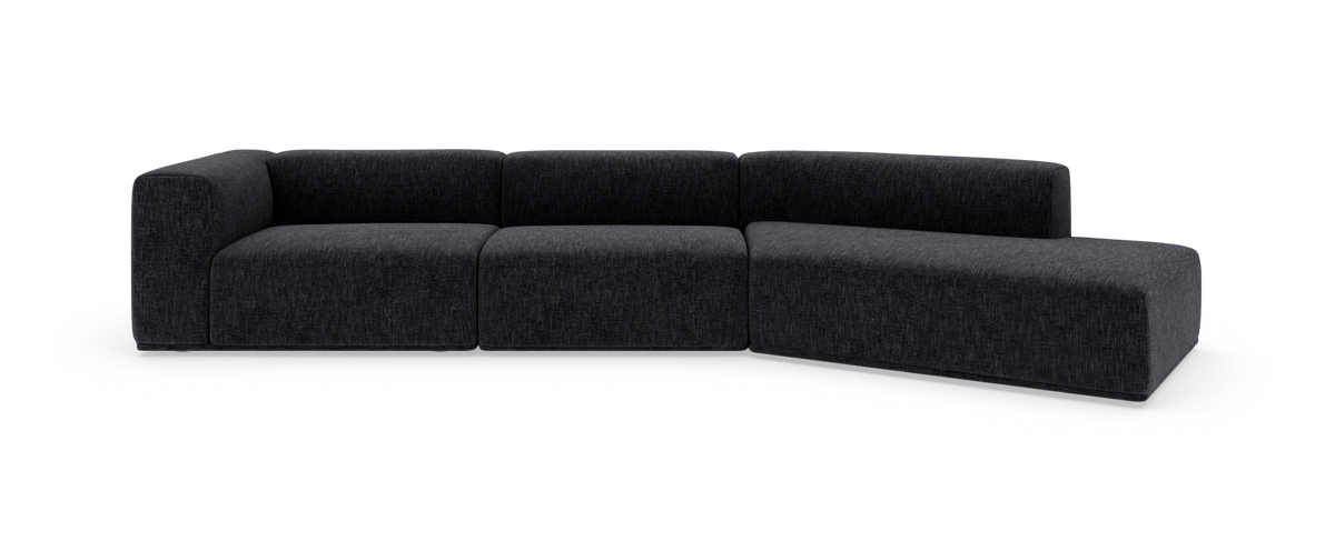 Mørkegrå modul hjørnesofa i stof, lav og blødt afrundet, fritlagt på hvid baggrund.