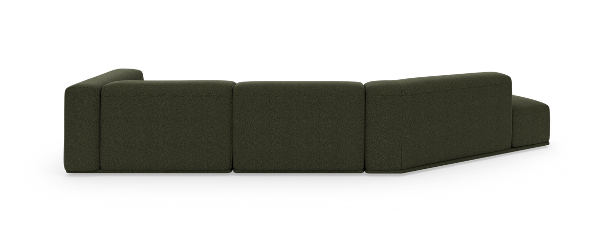 Mørkegrøn modulsofa set skråt bagfra på hvid studiobaggrund.