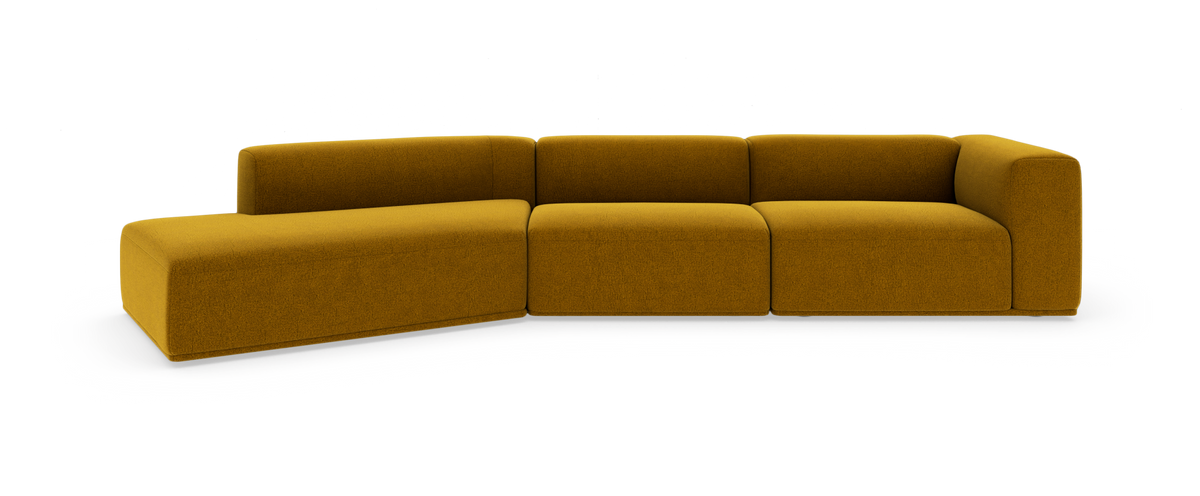 Modulsofa i sennepsgult stof, L‑formet med afrundede hjørner på hvid studiobaggrund.