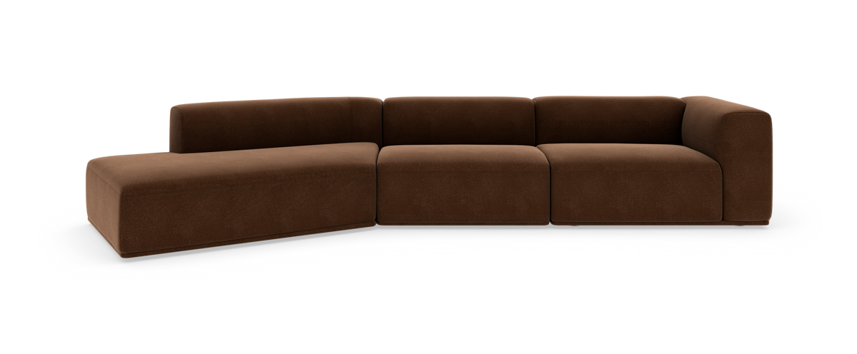 Brun modulsofa i L‑form med afrundede hjørner, lav ryg og ét armlæn til højre, frilagt på hvid studiebaggrund.