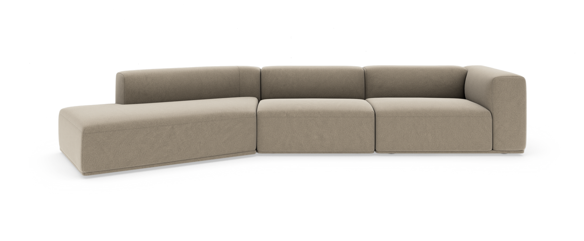 Beige modulsofa i L‑form med venstrevendt chaiselong og afrundede hjørner, frilagt på hvid baggrund.
