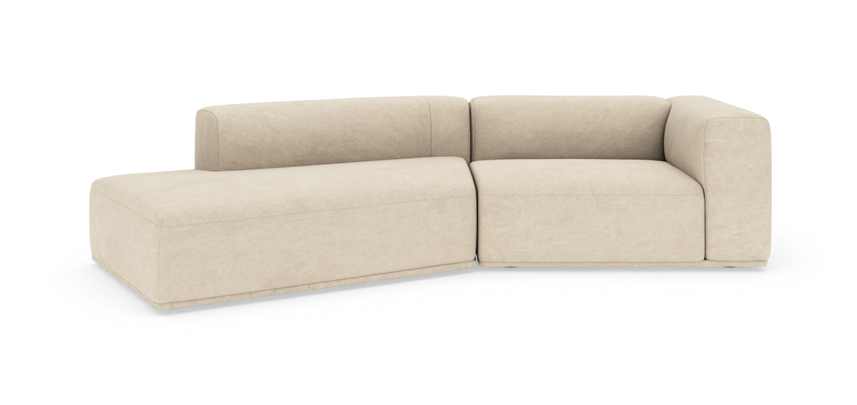 Beige L‑formet modulsofa med chaiselong til venstre på ren studiobaggrund.