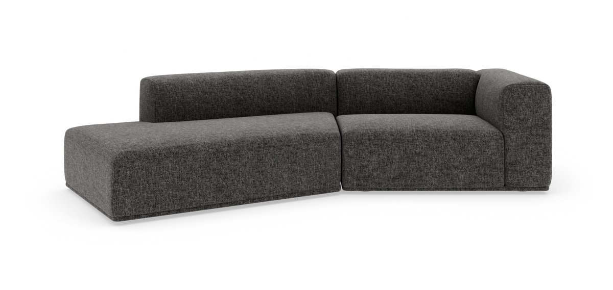 Mørkegrå modulsofa i L-form på hvid studiebaggrund.
