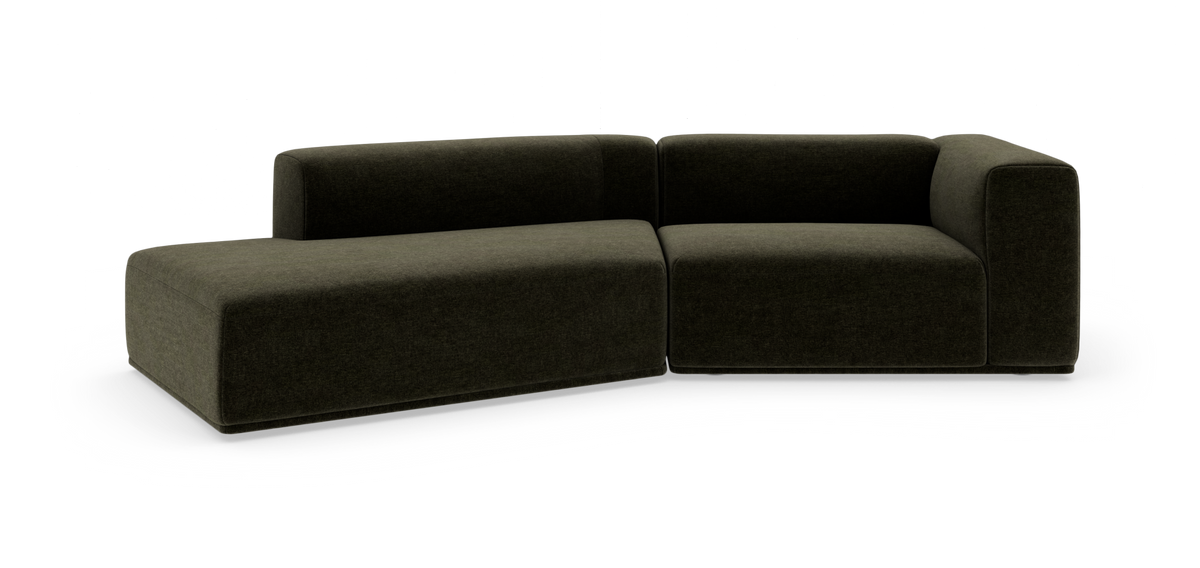 Modulsofa i mørkegrønt stof i L-form på hvid baggrund.