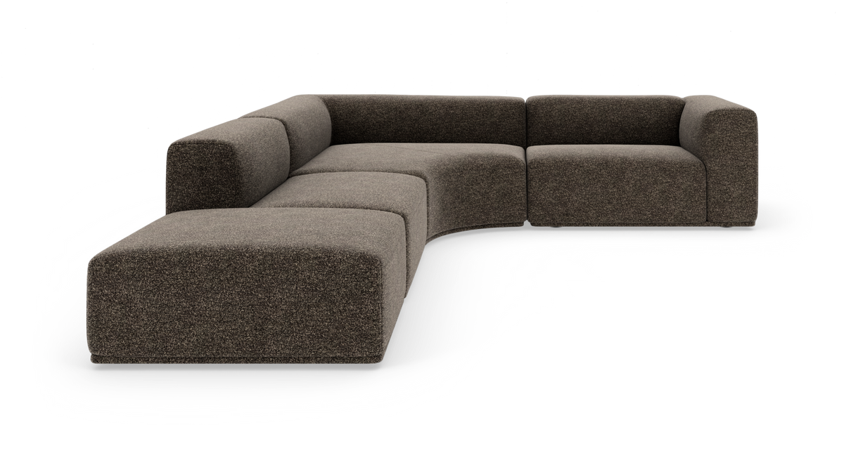 Modulær L-sofa i brungråt stof med afrundede former, frilagt på hvid baggrund.