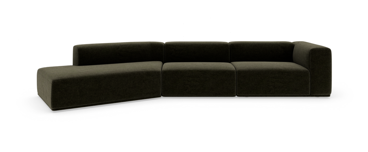 Modulsofa i mørk olivgrøn tekstil med venstrevendt chaiselong og brede blokformede sædemoduler.