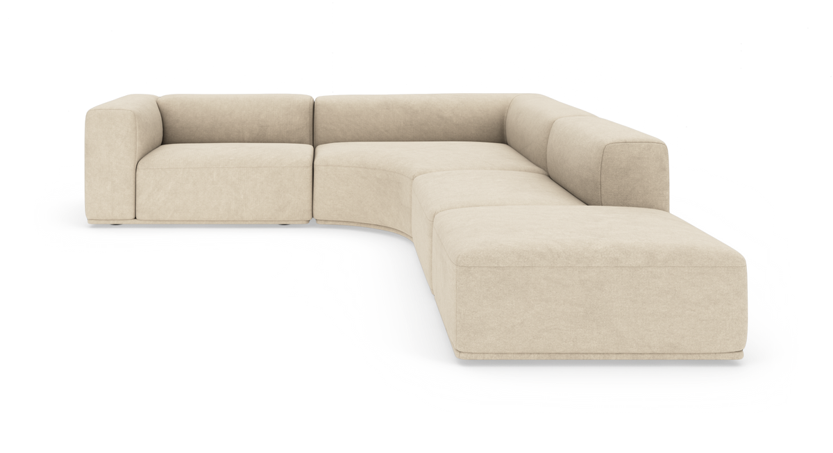 Beige modulsofa i L‑form med afrundede hjørner, frilagt på hvid baggrund.