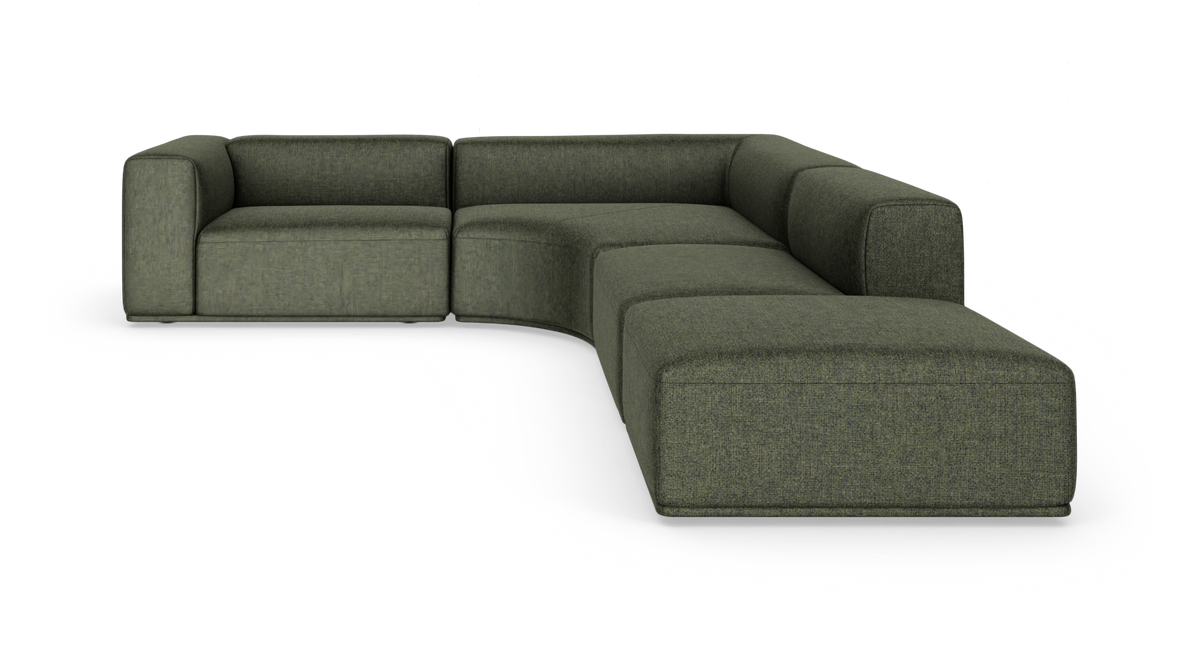 Modulsofa i mørkegrønt stof, L‑form med afrundet hjørnesektion, frilagt i studie.
