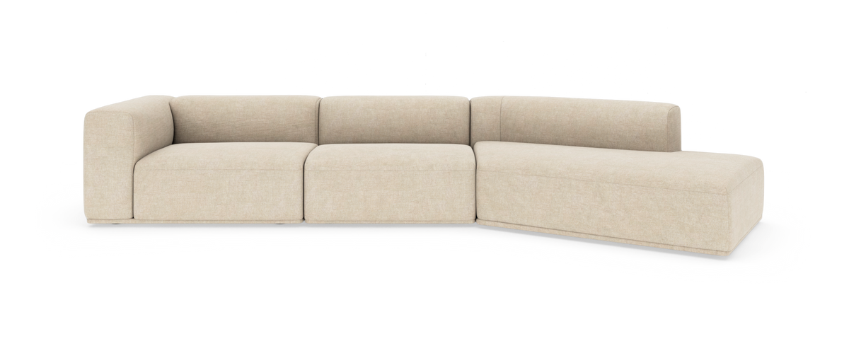 Beige modulsofa med chaiselong, blødt afrundede former og lav ryg i studieopsætning.