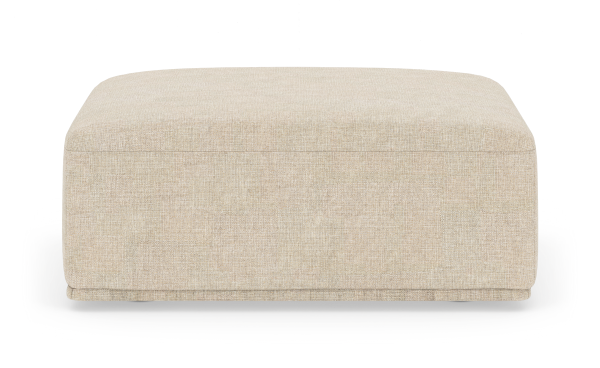 Beige kvadratisk puf/ottoman i stof frilagt mod hvid baggrund.