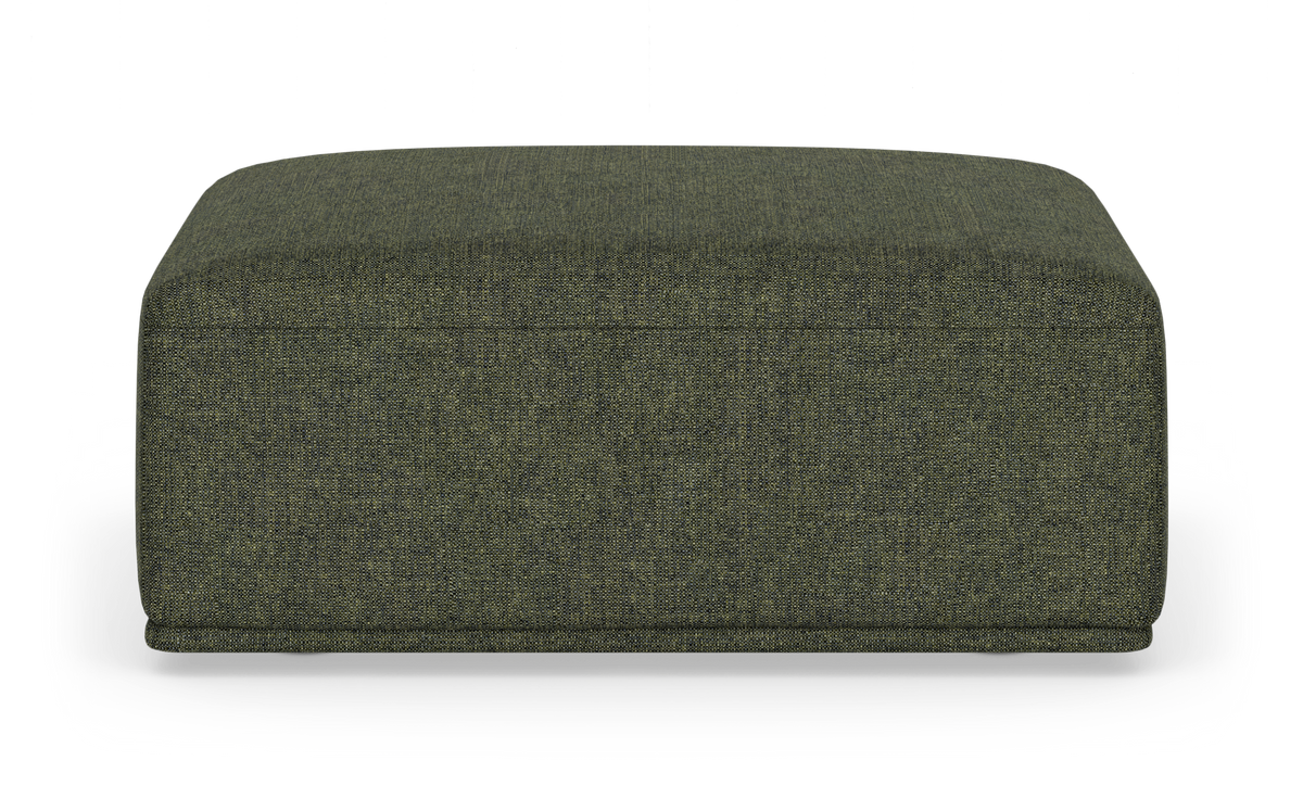 Grøn kvadratisk stofpuf/ottoman med lav, blød profil på hvid baggrund.