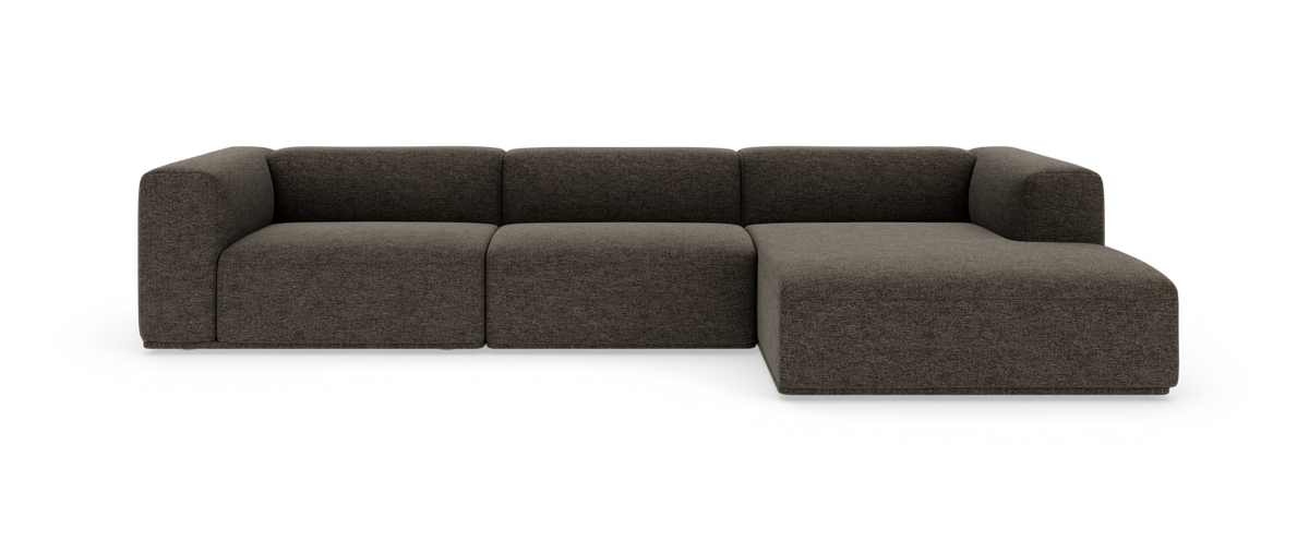 Modulær hjørnesofa i mørkgrå tekstil med chaiselong til højre, fotograferet forfra på hvid baggrund.