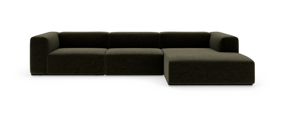 Modulsofa i mørkegrønt stof med højrevendt chaiselong, lav og blødt afrundet design.