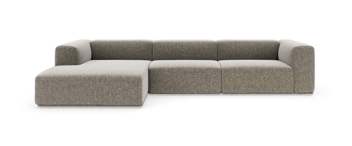 Modulsofa i grå‑beige stof med venstrevendt chaiselong; moderne, lav profil med blødt afrundede armlæn.