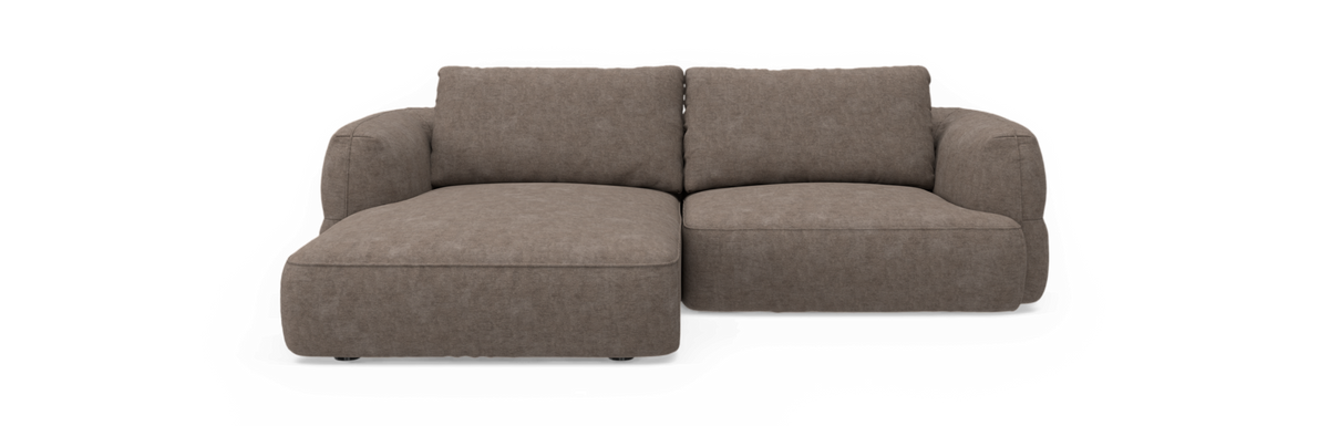 Brun stofpolstret hjørnesofa med venstrevendt chaiselong, tosædet, fotograferet forfra mod sort baggrund.